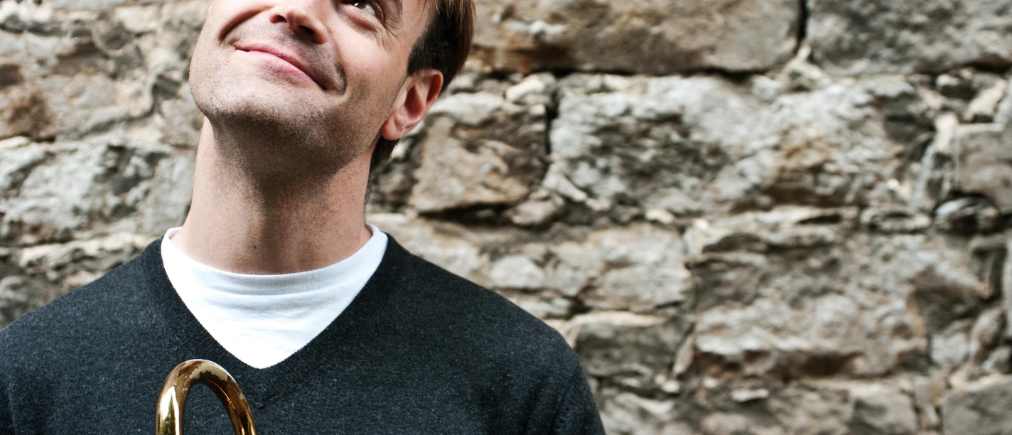 Shawn Grocott mit Posaune vor einer Wand
