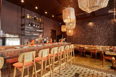 Bar Brio - Innenraum Innenraum der Bar Brio mit Tresen, gedeckten Tischen und warm leuchtenden Korblampen