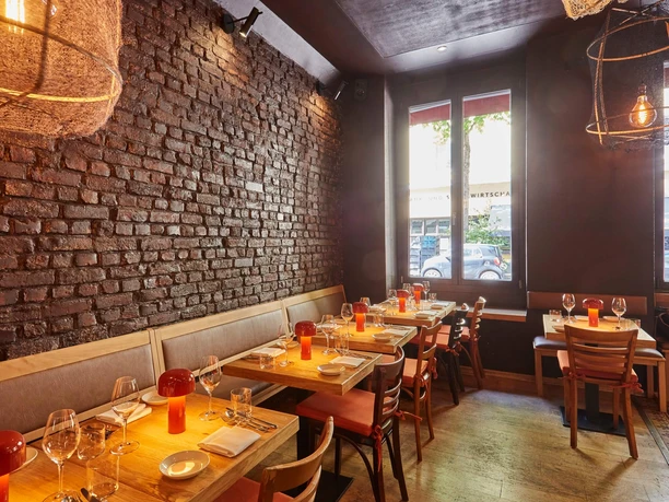 Bar Brio - Interior The interior of Bar Brio, featuring wooden tables, a brick wall, and warm lighting