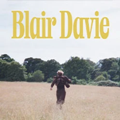 Gelber Schriftzug „Blair Davie“ über einer Person, die durch ein sommerliches Feld läuft
