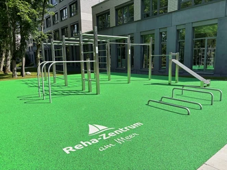 Trainingspark-Calisthenics-Park.jpg Calisthenics-Anlage mit grüner Trainingsfläche vor dem Reha-Zentrum am Meer.