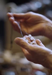 Neighborhood Market for Homemade Goods Hands hold a delicate necklace with light-colored pearls at the Veedelsmarkt, a market for handmade goods