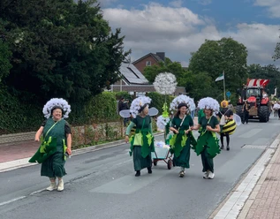 Schuetzenfest-Petersfehn.jpg Kostümierte Gruppe beim Festumzug des Schützenfests Petersfehn auf einer Straße.