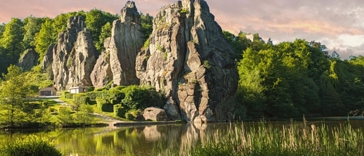 Externsteine im Abendlicht, mit Felsen, Wald und Spiegelung im Teich