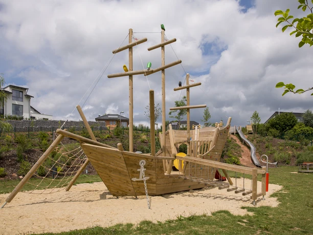 Piratenschiff mit seinen Klettermöglichkeiten Sie sehen das Holzpiratenschiff, des Spielplatzes Bockental. Es hat verschiedenste Möglichkeiten durch Klettergerüste und Wackelbrücke es im inneren zu erforschen.