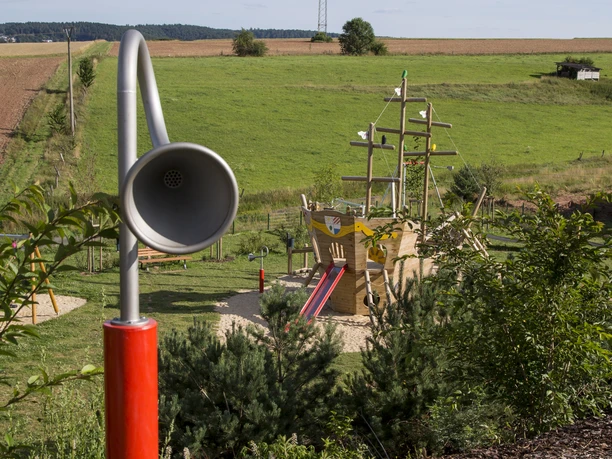 Spielplatztelefon mit bester Aussicht Sie sehen das rote Spielplatztelefon, was auf der oberen Etage steht. Das Rohrsystem führt in die untere Etage, wo der "Anruf" entgegen genommen werden kann.
