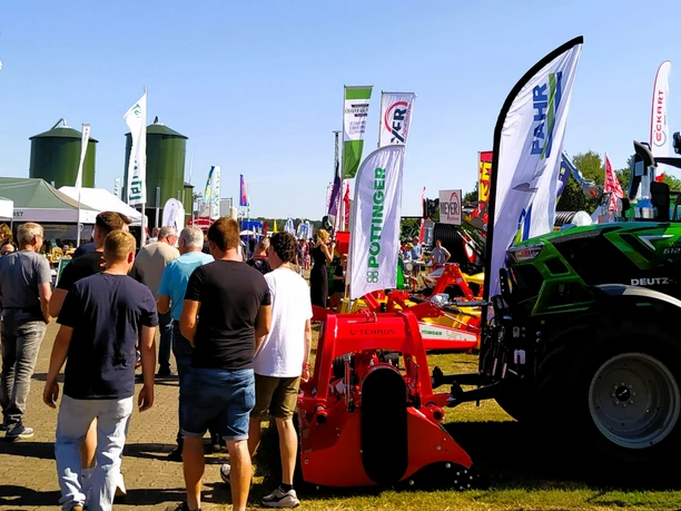 Besucher bestaunen die landwirtschaftlichen Fahrzeuge Besucher bestaunen die landwirtschaftlichen Fahrzeuge