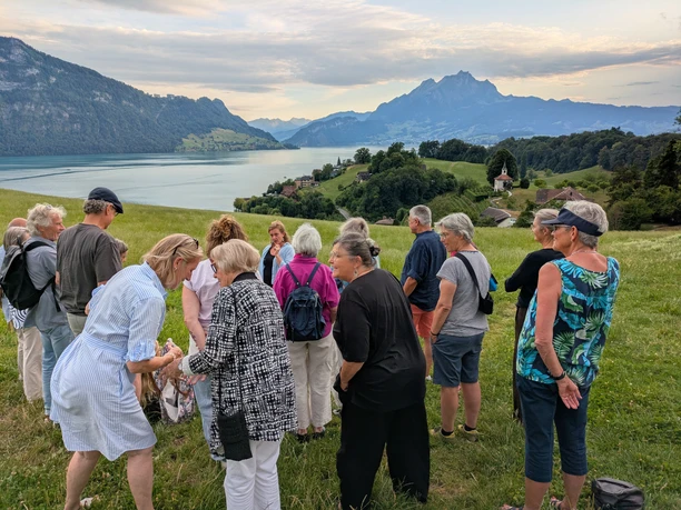 Lidobus_Sagenfahrt Gäste der Sagenfahrt auf Wiese mit Blick auf Vierwaldstättersee und Pilatus in Weggis