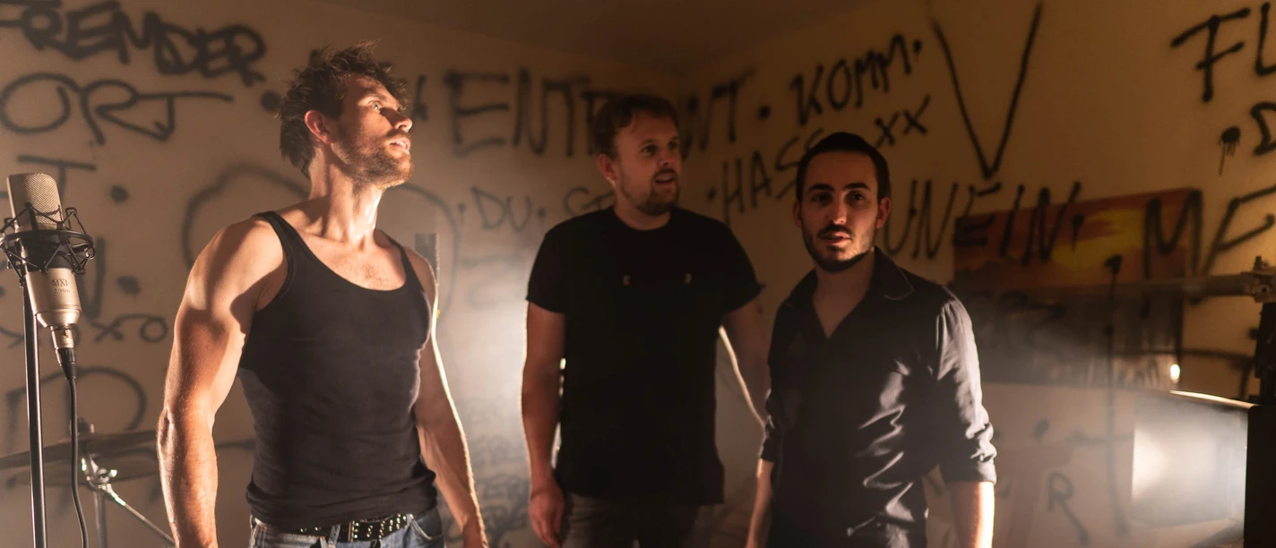 Badstreet Noise Drei Männer mit Mikrofon und Schlagzeug in Raum mit Graffiti