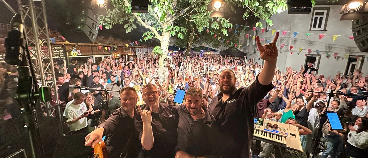 Secret Basement Open-Air-Konzert mit Band auf Bühne, Publikum hebt Hände