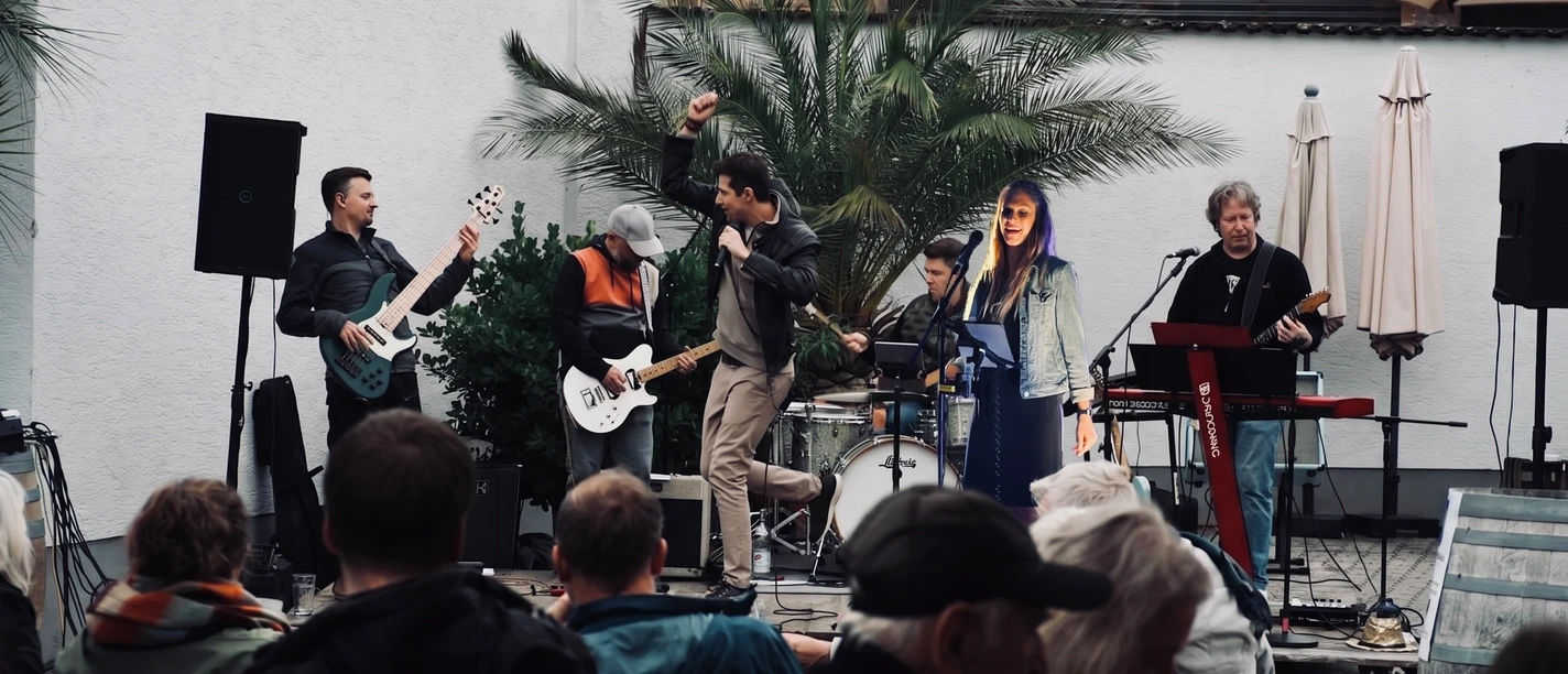 GERTI's Liveband spielt im Innenhof, Publikum vor kleiner Bühne