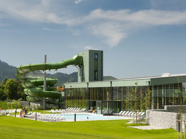 Alpentherme Ehrenberg - Aussenbereich Therme Außenbecken der Alpentherme Ehrenberg mit grüner Rutsche, Liegewiese und Alpenblick