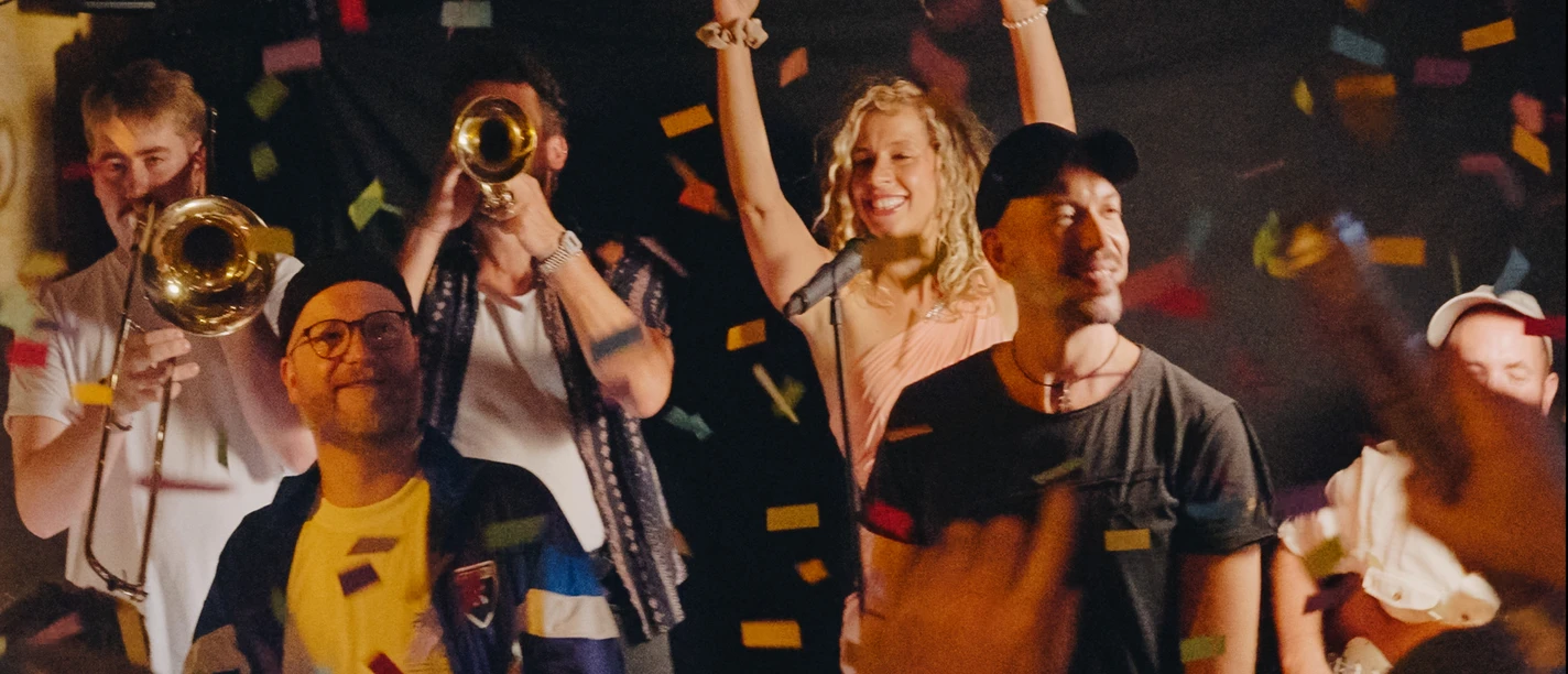 Grundfunk Liveband auf Bühne, Konfetti und Publikum bei Konzert