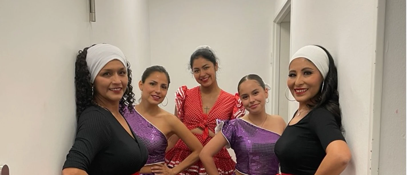 Tanzgruppe Pasión Afro Perú Fünf Tänzerinnen in Bühnenkleidung in schmalem Flur