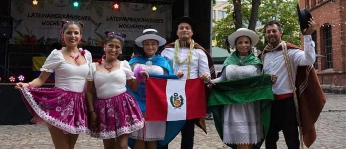 Raíces Peruanas Frankfurt Dance Group Group in traditional dress with flags before stage at city festival
