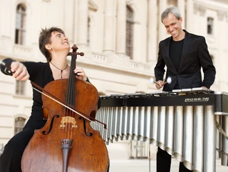 Musiker mit Cello und Vibraphon vor historischem Gebäude