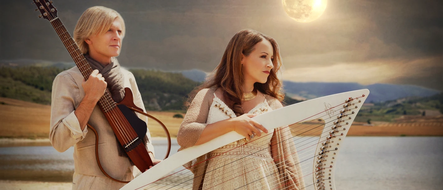 Maite Itoiz und John Kelly mit Harfe und Gitarre vor See und Vollmond.
