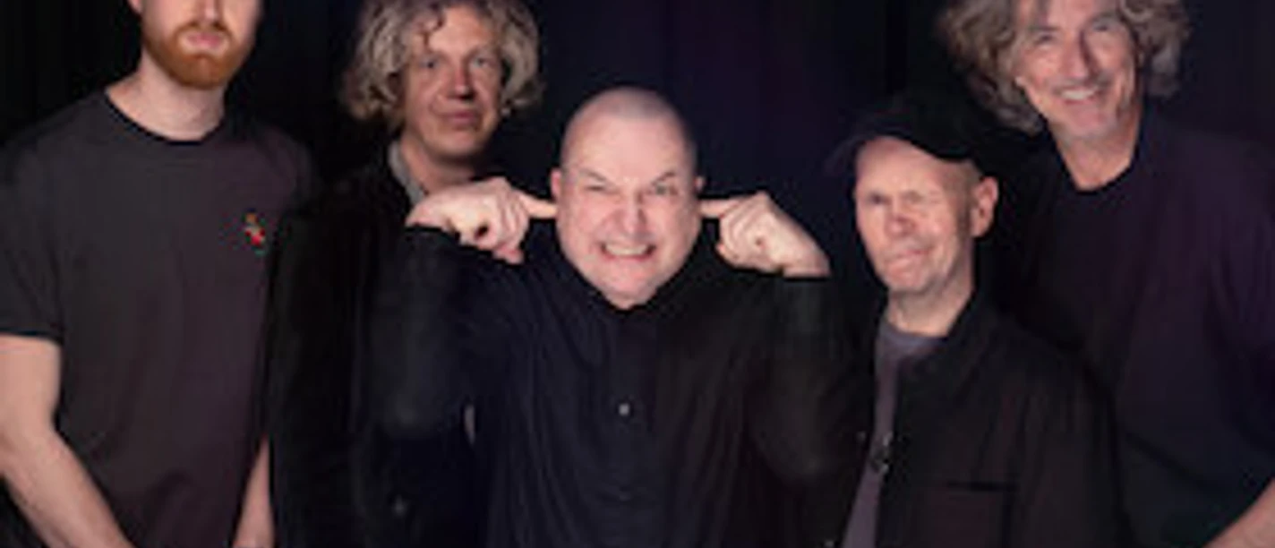 Fünf Musiker der Tribute-Band True Collins vor dunklem Bühnenhintergrund.