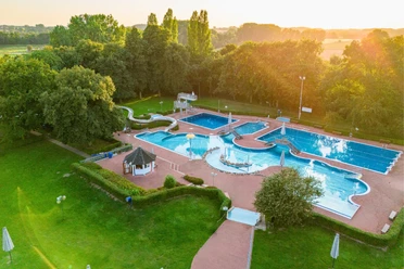 Luftaufnahme des Bega Bads mit mehreren Becken, Rutsche und Sprungturm im Abendlicht