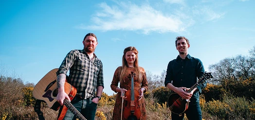 selected_csm_cropmiddle_Shackleton-Trio-Album-Shoot_c_Simon-Boosey-photography_reduziert_fuer_Web_6aa5d9f96c.jpg Shackleton Trio mit Gitarre, Geige und Mandoline vor blauem Himmel