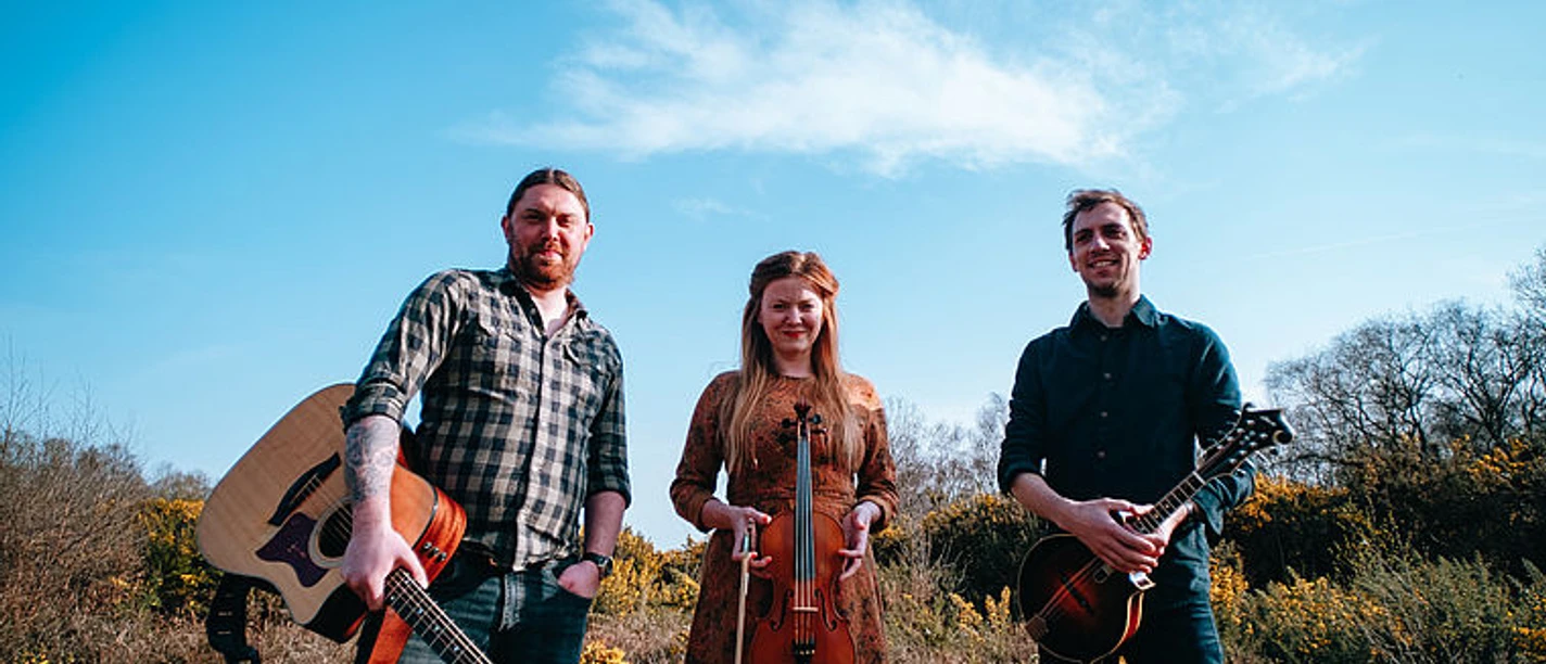 selected_csm_cropmiddle_Shackleton-Trio-Album-Shoot_c_Simon-Boosey-photography_reduziert_fuer_Web_6aa5d9f96c.jpg Shackleton Trio mit Gitarre, Geige und Mandoline vor blauem Himmel
