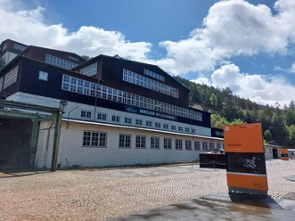 Ertsverwerking op de Rammelsberg met een oranje wegwijzer voor een beboste helling.
