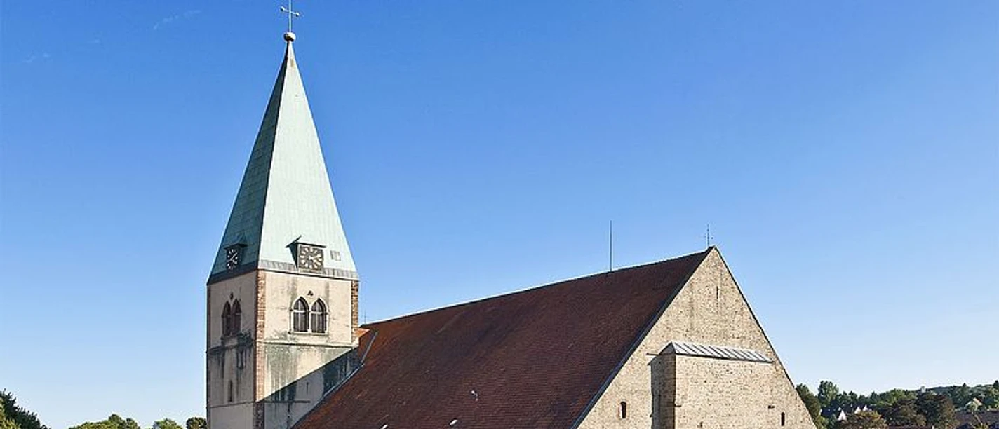 Kirche St. Marien in Lemgo mit Turm, rotem Dach und blauem Himmel