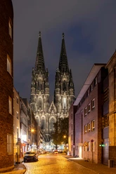 Blick auf den Kölner Dom Nächtlicher Blick durch eine Kölner Straße auf die beleuchteten Türme des Doms