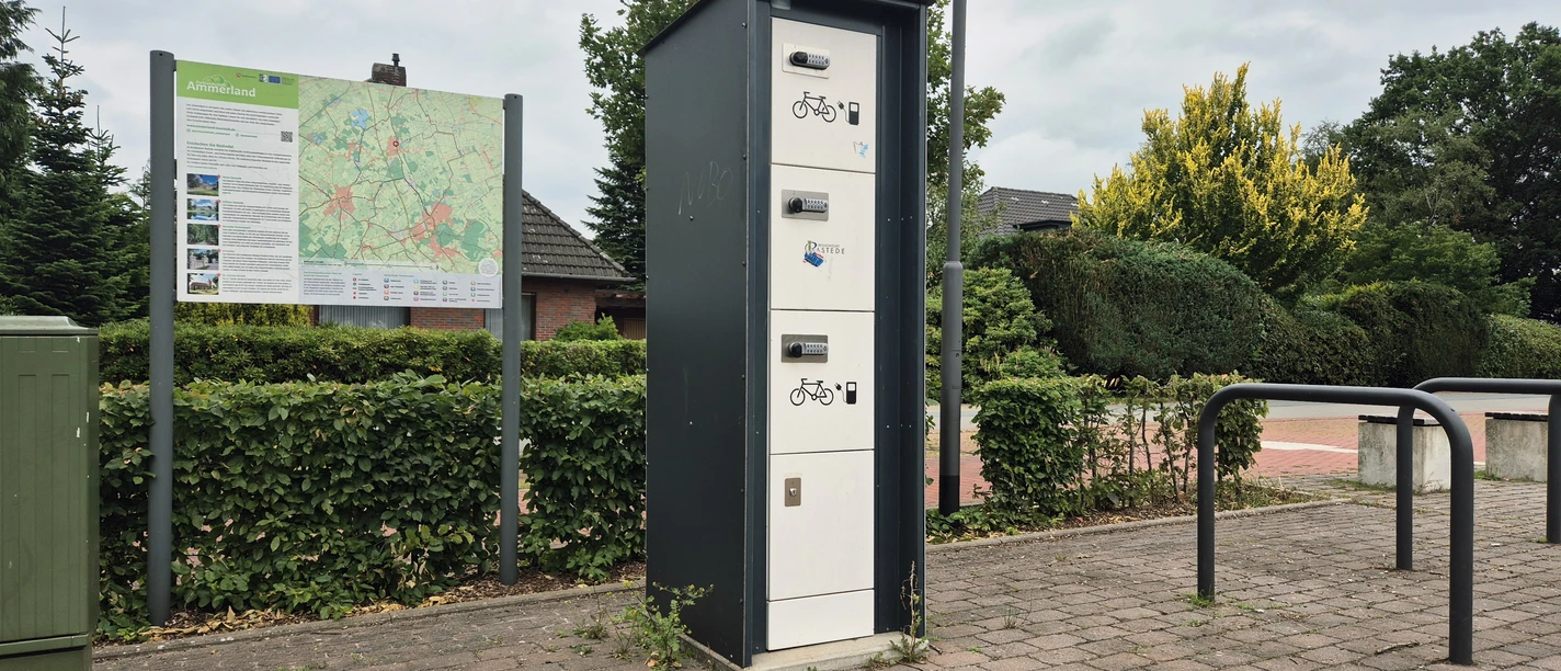 E-Bike-Ladestation mit Infotafel und Fahrradbügeln am Dorfplatz Hahn-Lehmden.