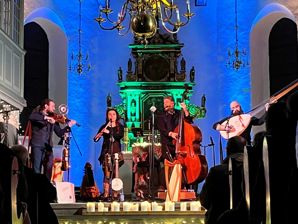 Ensemble Laway bei Kerzenschein in blau beleuchteter Kirche mit Geige, Flöte, Bass und Laute.