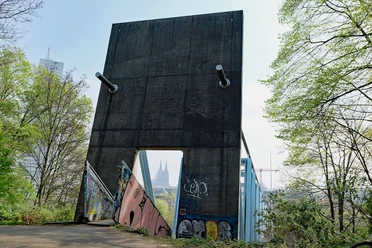 Betonbauwerk mit Graffiti am Herkulesberg, dahinter Blick auf den Kölner Dom