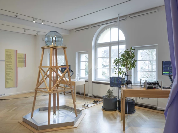 MGGU - Ausstellungsraum Raum mit Installation, Monitoren und Pflanze im Museum