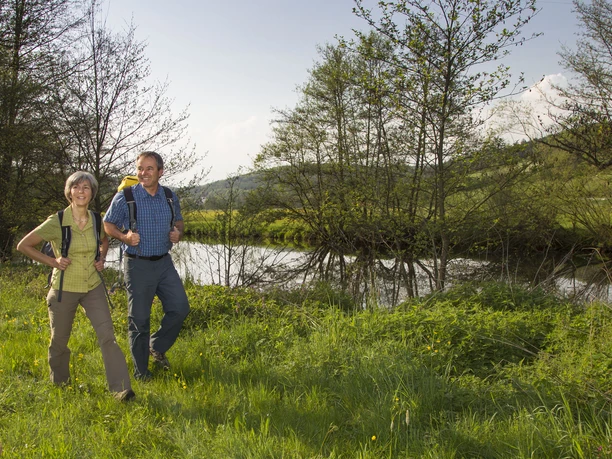 An der Vils bei Traidendorf Wanderpaar auf grüner Wiese an einem Fluss mit Bäumen im Hintergrund bei Traidendorf.