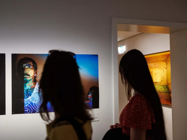 Visitors view photographs in an exhibition gallery
