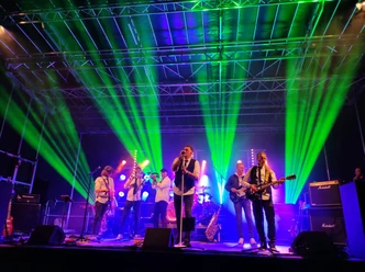 Sexxy - Westenhagen Band beim Rock am Backs Konzert auf einer Bühne mit grünen Scheinwerfern.