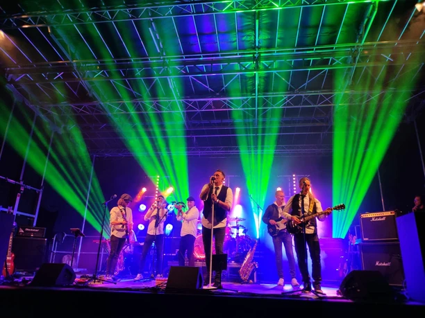 Sexxy - Westenhagen Band beim Rock am Backs Konzert auf einer Bühne mit grünen Scheinwerfern.