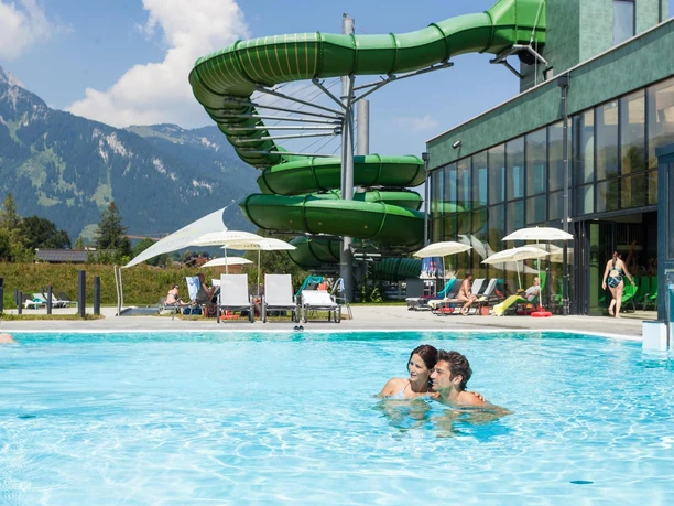 Alpentherme Ehrenberg Außenbecken Außenbecken der Alpentherme Ehrenberg mit Badenden, grüner Rutsche und Bergblick
