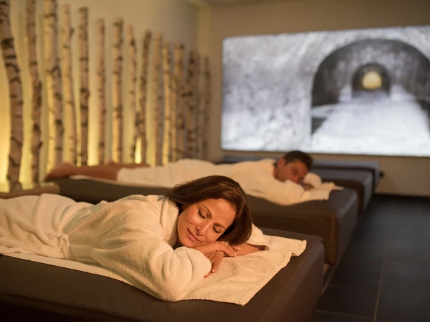 Alpentherme Ehrenberg Sauna Dunkelruheraum Zwei Personen ruhen in Bademänteln auf Liegen im Dunkelruheraum der Alpentherme Ehrenberg