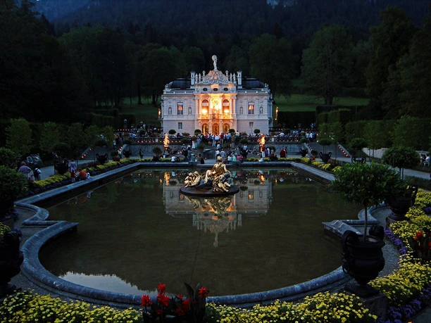 Schloss Linderhof Ludwignacht Erleuchtetes Schloss Linderhof bei Nacht mit Wasserbecken, Brunnen und Gästen im Park