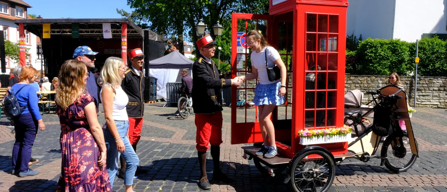 Museum of Communication - Payphone Red phone box on bicycle, people at street festival