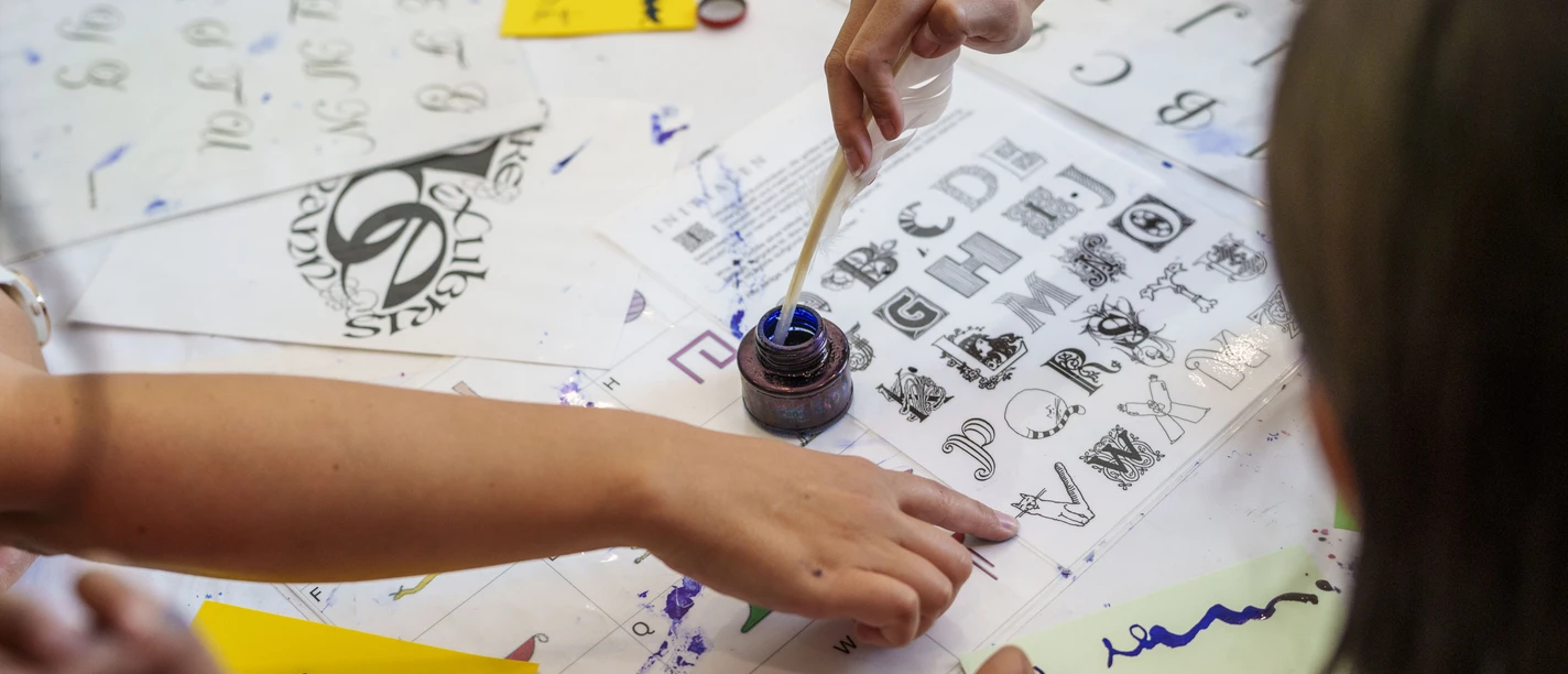 Museum für Kommunikation - Kreativwerkstatt Kinder schreiben mit Feder und Tinte bei Mitmachaktion