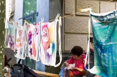 Museum für Kommunikation - Taschenwerkstatt Bemalte Stoffbeutel hängen auf Leine bei Straßenaktion