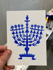 Judengasse Museum - Hanukkah Card Hand holding card with blue print of a candelabrum