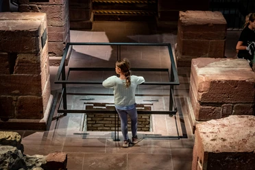 Museum Judengasse - Kinder Sommer Workshop Kind blickt in archäologische Ausgrabung im Museum