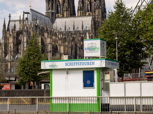 The KölnTourist passenger boat - Ticket Sales on the Banks of the Rhine KölnTourist boat tour kiosk on the banks of the Rhine, with Cologne Cathedral in the background