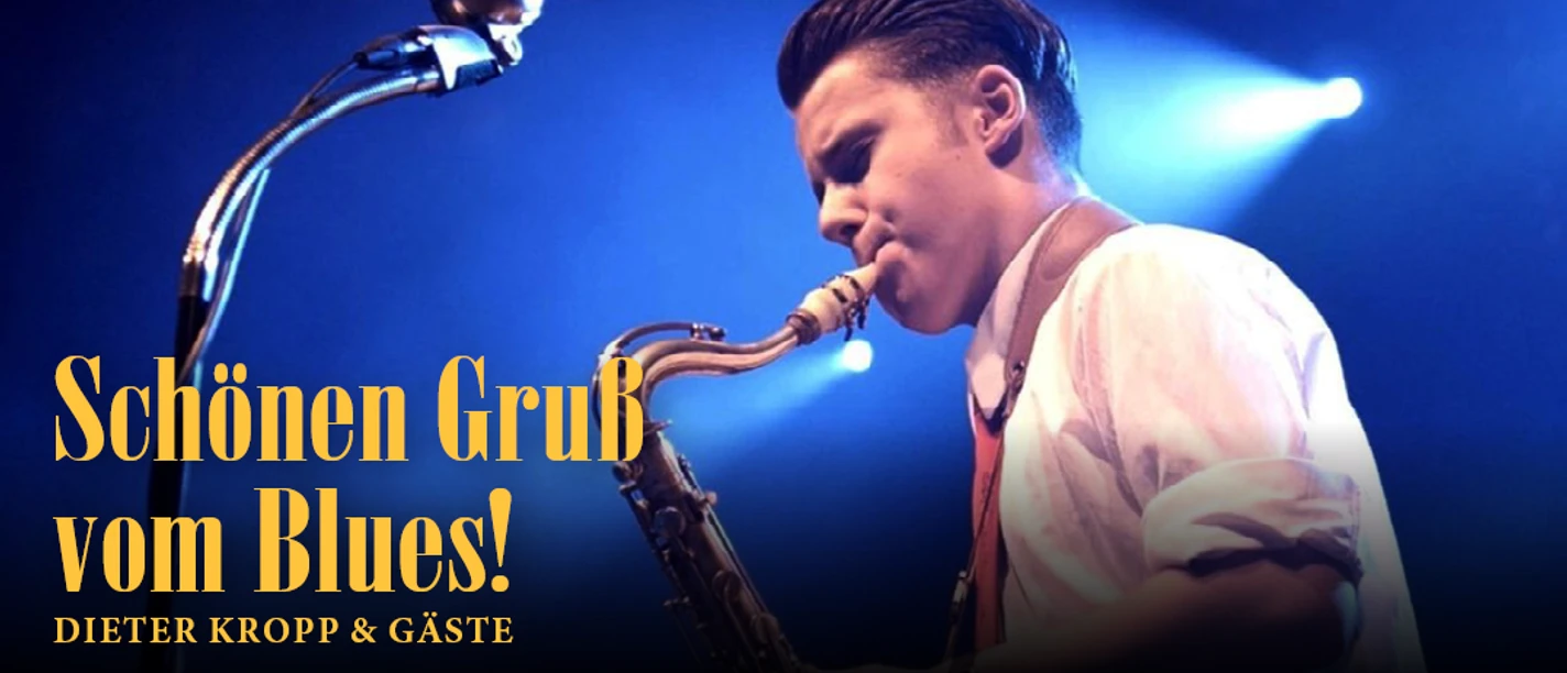 Saxofonist auf blau beleuchteter Bühne, mit Schriftzug „Schönen Gruß vom Blues!“