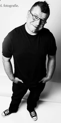 Ingo Margraf Mann in schwarzem T-Shirt und Brille lächelt in die Kamera, schwarz-weiß Foto.