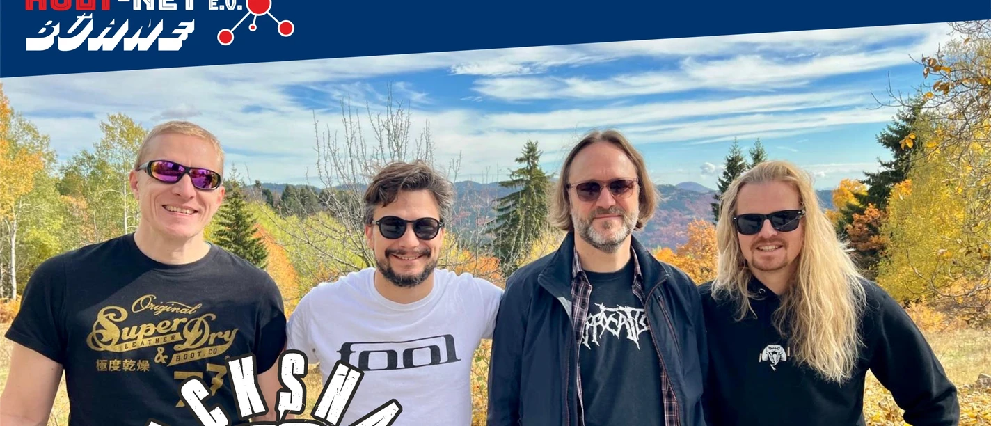 KULT-Net e.V. - BLACKSNAKE Vier Bandmitglieder lächeln draußen für ein Foto