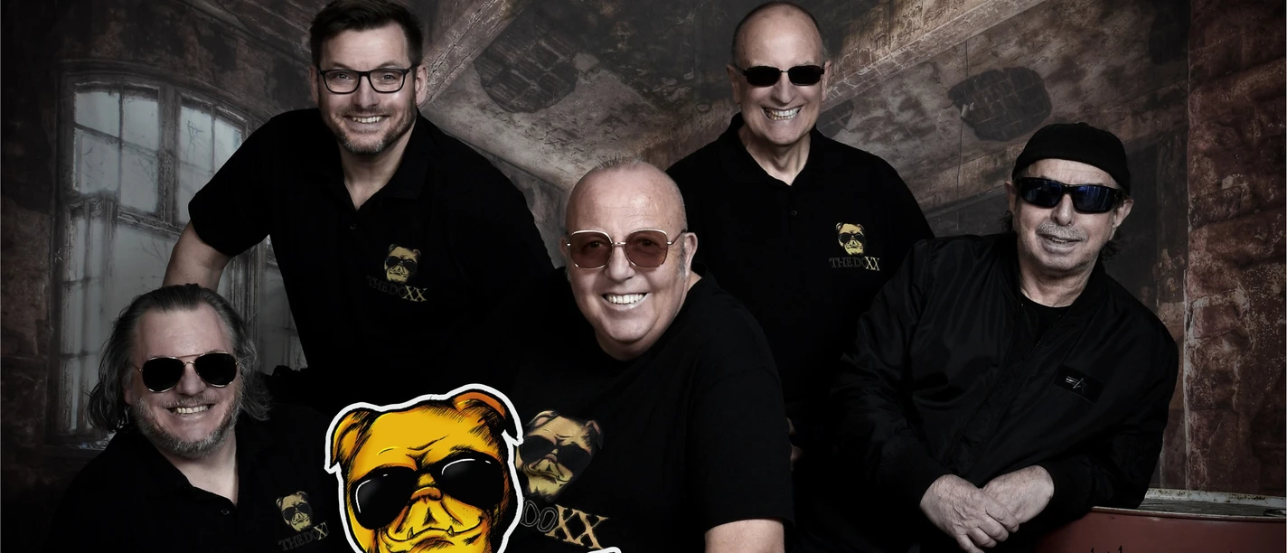 KULT-Net Bühne - THE DOXX Band "The Doxx" lächelt in schwarzer Kleidung mit Sonnenbrillen