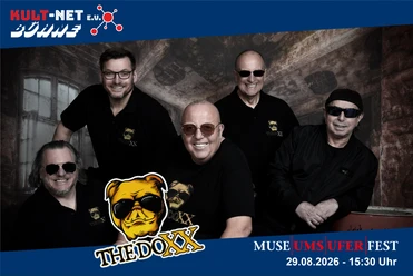 The band "The Doxx" smiles while wearing black clothes and sunglasses
